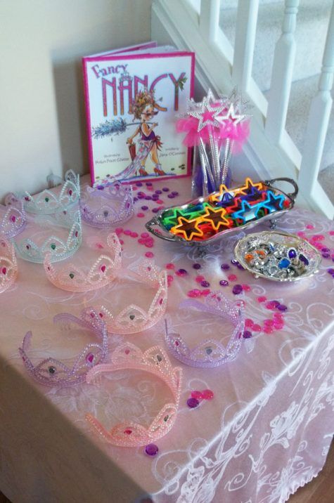 a table topped with lots of tiaras next to a greeting card and other items