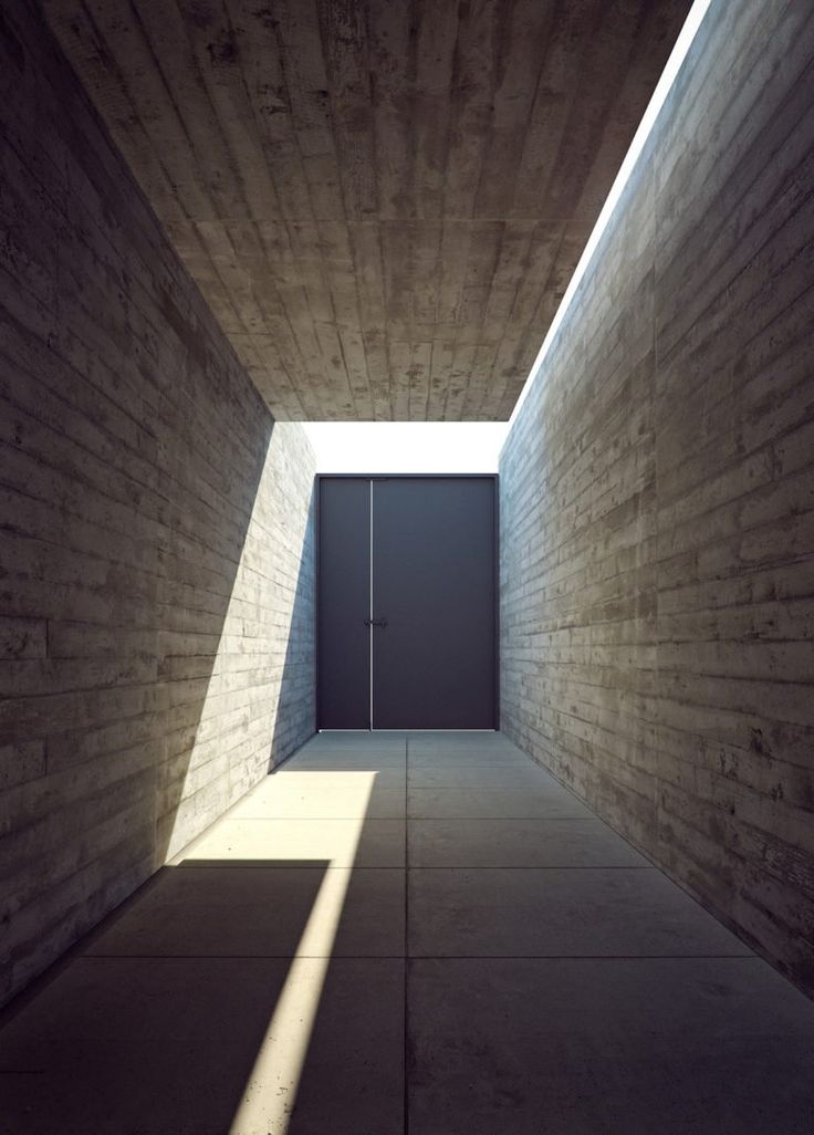 an empty room with a door and light coming in from the ceiling to the floor