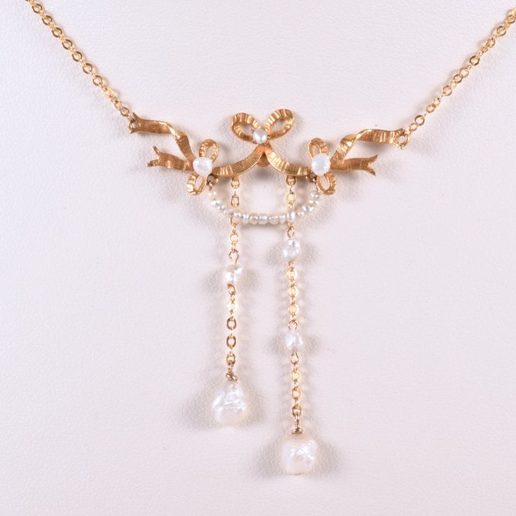 "We have a charmingly beautiful 14k yellow gold negligee antique necklace, with a dainty sweet bow and gorgeous seed pearls. If you're a lover of all things cute and sweet you will love this unique delicate piece.  Would pair well with todays popular prairie look for your collection. This piece dates back to the early 1900's during the Edwardian jewelry period. Simply gorgeous.  Antique Necklace - Antique 14k Yellow Gold Edwardian Natural Seed Pearl Necklace  14k Yellow Gold  Natural Seed Pearls Elegant Gold Necklace With Ribbon, Delicate Yellow Gold Evening Necklace, Elegant Yellow Gold Jewelry With Ribbon, Delicate Yellow Gold Necklace For Evening, Heirloom Pearl Pendant Necklace For Wedding, Elegant Jewelry With Ribbon For Wedding, Elegant Wedding Jewelry With Ribbon, Victorian Pearl Chain Necklace As Gift, Gold Ribbon Necklace For Wedding