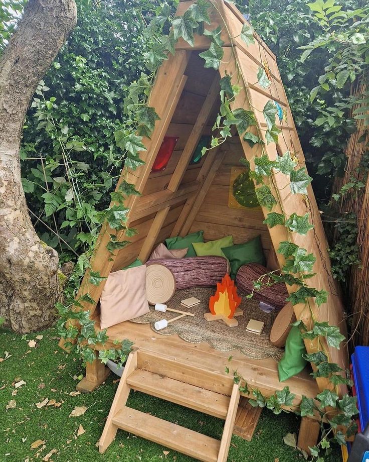 a small wooden structure with plants growing on the sides and fire pit in the middle