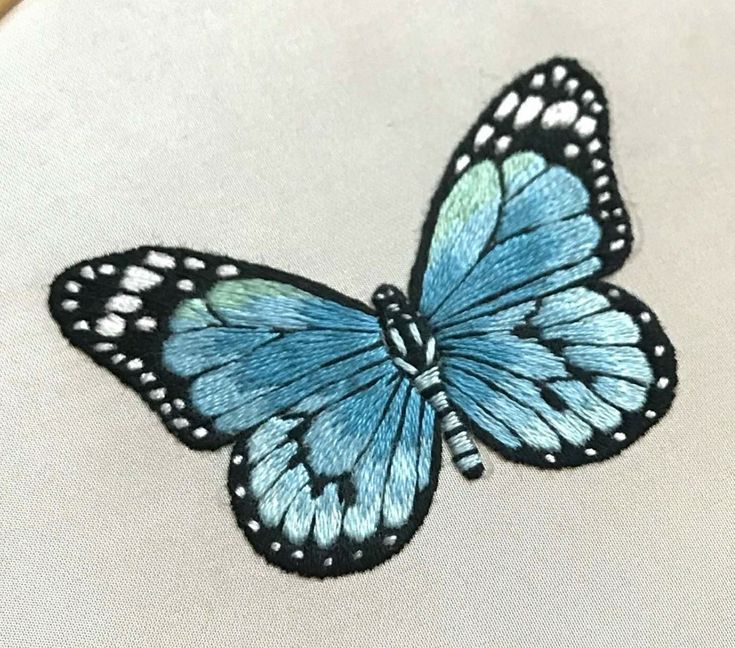 a blue butterfly sitting on top of a white pillow