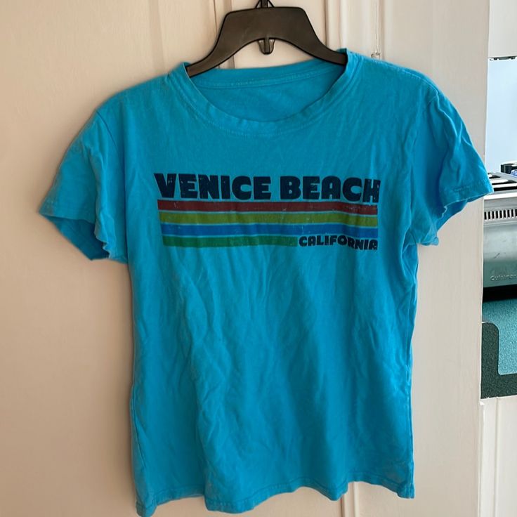 Super Cute Venice Beach T-Shirt In Preloved Condition. Tags Removed, But It Is A Size Small. Wrinkles From Storage. Very Comfortable And Cute! Too Small For Me Now Bc My Chichis Are Too Big Lol. Open To Offers! New To Poshmark? Sign Up Using My Code R_glover And Receive $10 Off Your First Purchase! Tags: Casual/Outdoor/Outside/Nwt/Nwot/Cool/Hipster/Surfer/Beach/West/Coast Blue Short Sleeve Tops For Beach Season, Blue Crew Neck Shirt For Vacation, Retro Blue Top With Letter Print, Retro Blue Tops With Letter Print, Blue Crew Neck Tops For Beach Season, Blue Short Sleeve T-shirt For Beach Season, Blue Short Sleeve T-shirt For Beach, Blue Crew Neck Top For Beach, Retro Blue T-shirt With Text Print