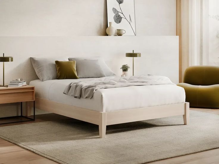 a white bed sitting in a bedroom next to a wooden table and chair on top of a hard wood floor