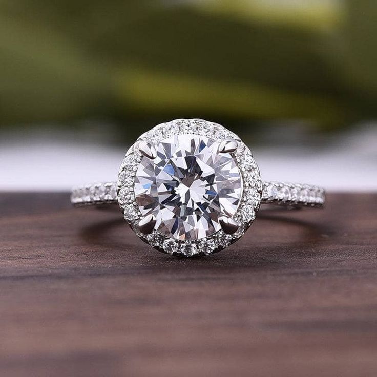 a white diamond ring on top of a wooden table