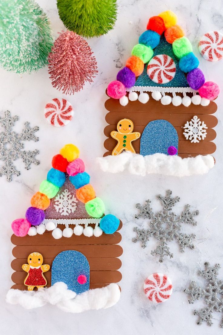 two gingerbread houses made out of felt with candy and snowflakes around them