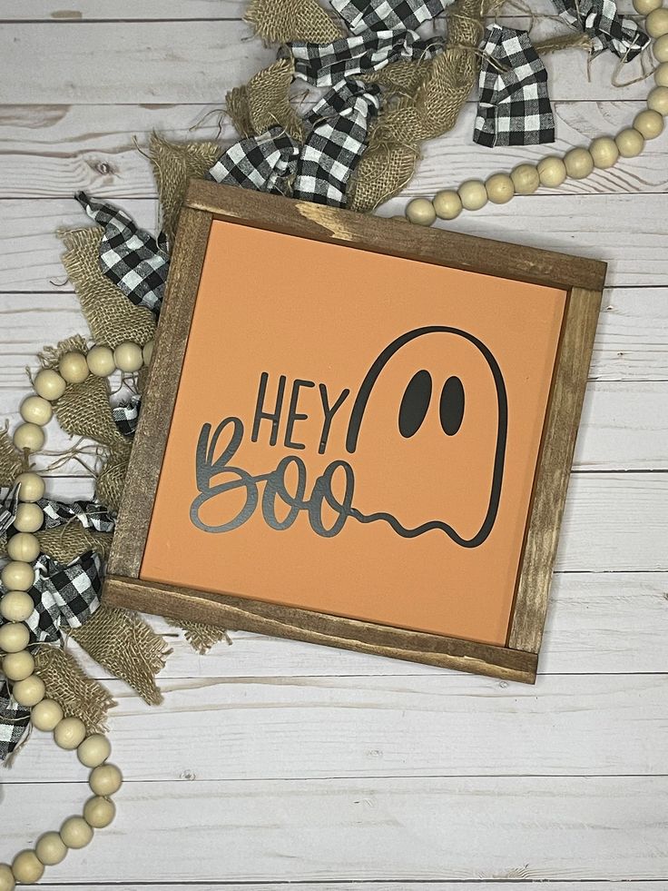 a sign that says hey boo on it next to some beads and a bead necklace