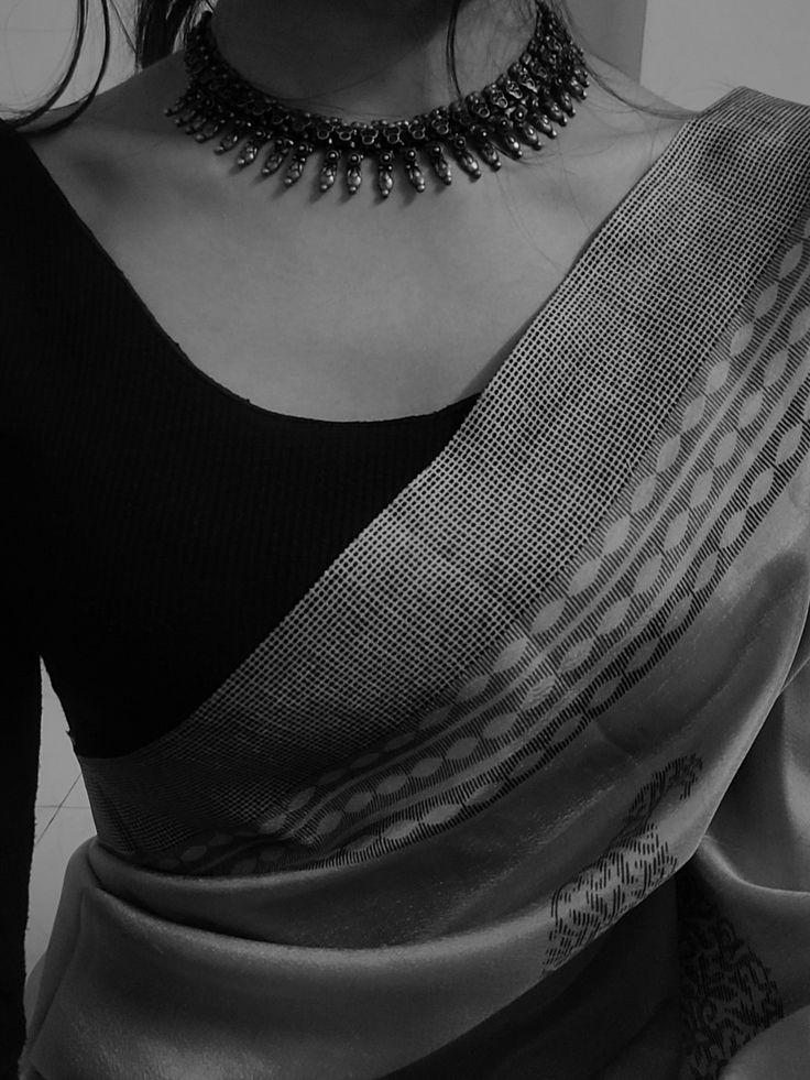 a woman wearing a black and white sari