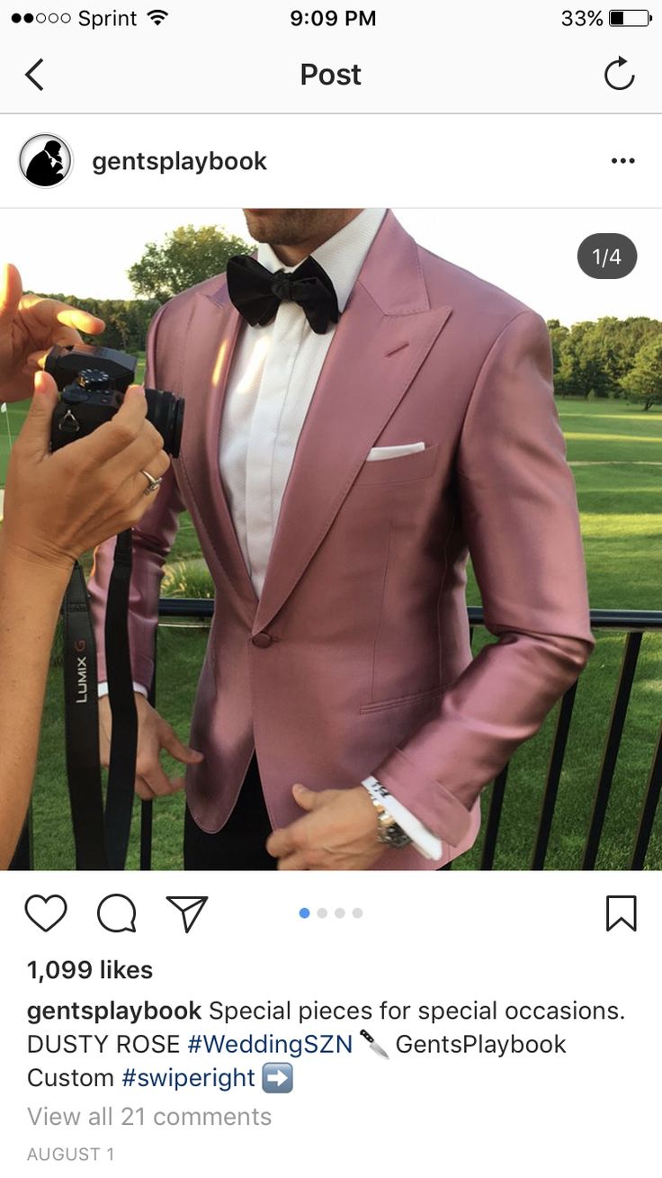 a man in a pink tuxedo taking a photo with his camera on instagram