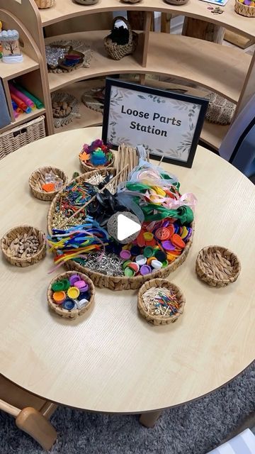 a round table with baskets on it and a sign in the middle that reads loose parts station