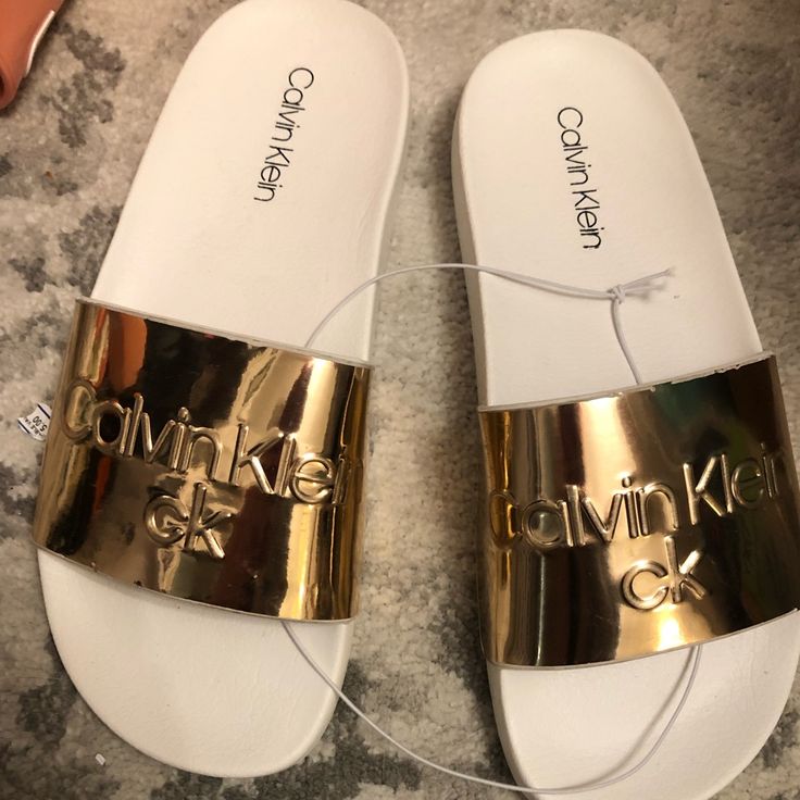 Some Nice Calvin Klein Slides To Wear Out And About Or Inside The House. Size 6m, Fits Up To A Womens 7.5 Without Socks. Unisex, Item Is New With Tags Casual Gold Flip Flops With Flat Heel, Casual Gold Flat Heel Flip Flops, Gold Flat Casual Flip Flops, Casual Closed Toe Gold Flip Flops, Casual Gold Closed Toe Flip Flops, Gold Casual Slide Sandals, Casual Gold Slide Sandals, Gold Flat Slides For Summer, Gold Round Toe Slides For Beach