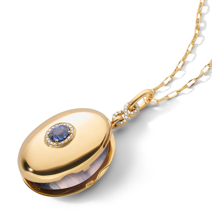 The little blue dress of lockets. Let the infinity locket with it's slim and classic profile be a foundation piece for your wardrobe. The locket has a diamond pave infinity inspired bail with a center cornflower blue sapphire and diamond halo. Your stories are important, let our infinity locket help you tell them. Locket holds two images. Fill your locket with The Locket Bar®. 18K Yellow Gold 20" Gold Chain with loop at 18" for adjustability or 30" Gold Chain Set with Blue Sapphire and White Dia Luxury Blue Locket Jewelry, Elegant Locket Necklace With Detachable Pendant For Anniversary, Elegant Diamond Locket Necklace, Elegant Locket Necklace With Cable Chain For Gifts, Elegant Yellow Gold Locket Necklace, Elegant Oval Locket Necklace With Adjustable Chain, Elegant Oval Pendant Locket Necklace, Elegant White Gold Locket Necklace For Formal Occasions, Elegant Medallion Locket Necklace With Adjustable Chain