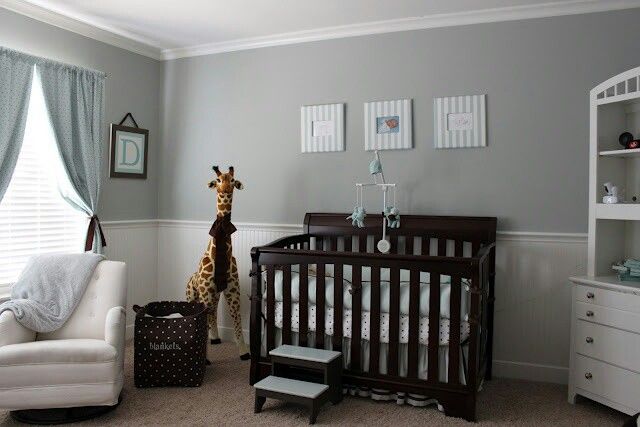 a baby's room with a giraffe in the corner