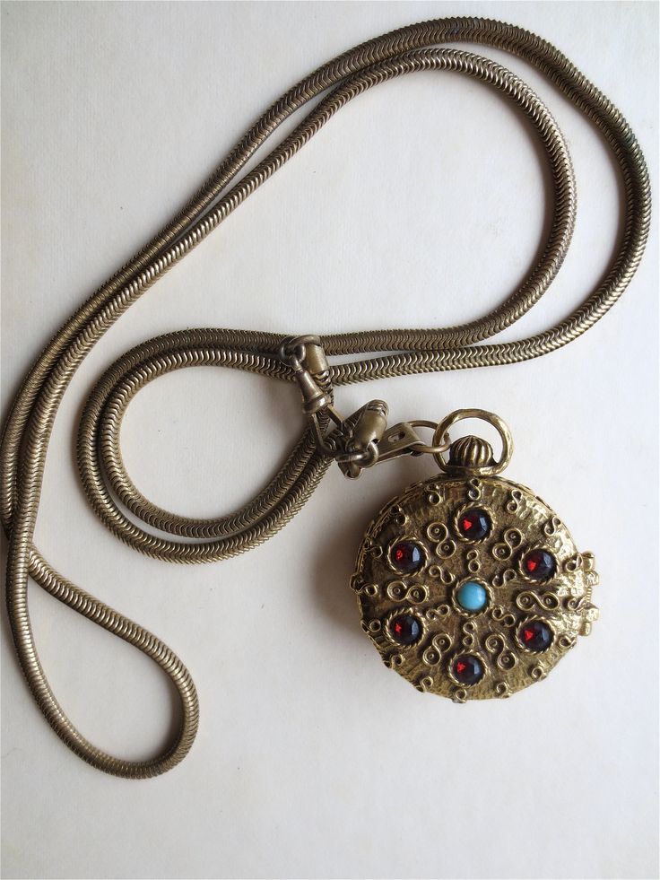 "Goldette N.Y. - Solid Perfume Locket - Pocket Watch Style Pill Box - on Old Brass Watch Fob Chain - Vintage 1960s Goldette N.Y. - Founded in 1958 and known for designs reminiscent of bygone times... In particular- their Victorian- inspired jewelry. From the 1960s, this is such a piece... A bejeweled Pocket Watch. In a warm Antiqued Brass Gold-tone- with Rhinestone accents of Garnets and Turquoise. A large Diamondesque jewel adorns the reverse. This is a nice tight hinge on the Locket or little Perfume Locket, Buy Stamps, Solid Perfume, Watch Chain, Inspired Jewelry, Brass Gold, Vintage 1960s, Pocket Watch, Locket