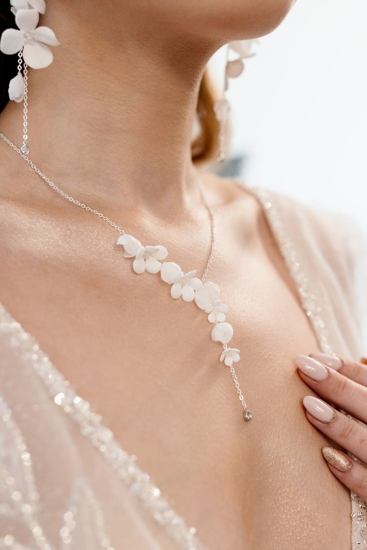 a close up of a woman wearing a necklace with flowers attached to it's neck