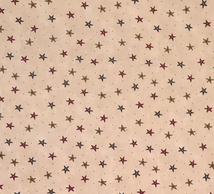 a beige background with red and black stars on it