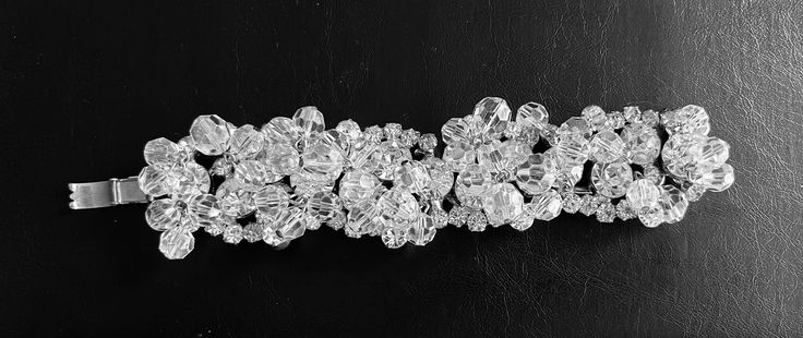 "A  stunning vintage bracelet.  Silver tone metal set with clear rhinestones and embellished with crystal aurora borealis beads.  The clasp closes perfectly and it has a safety chain. Beautiful craftsmanship.  This bracelet is unique and perfect for that special occasion.   A wonderful piece of jewelry for a bride.  Measurements Width - 1 1/4\" Length - 4\"   Happy to answer questions and or provide additional pics Please note that my store doesn't accept returns and doesn't ship internationally" Silver Crystal Embellished Bracelet Gift, Silver Crystal Embellished Bracelet For Gift, Costume Jewelry Crystal Bracelet With Rhinestones, Crystal Bracelet With Rhinestones And Round Beads, Crystal Bracelet With Round Rhinestones, Luxury Beaded Bracelets With Sparkling Stones For Wedding, Sparkling Crystal Bracelet In Costume Jewelry Style, Sparkling Stones Beaded Bracelet For Wedding, Silver Costume Jewelry Crystal Bracelet For Wedding