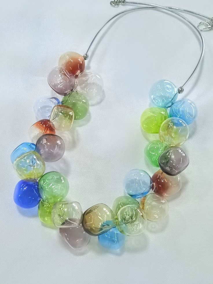 All products are handmade and unique. All beads are made by myself, in my own studio in Turkey-Selçuk-Şirince village. For my work i used Effetre (Moretti) - İtalian glass and the others. Shaped with breath. Stainless steel wire, transparent silicone cord and nickel free clasp. About 50 cm  long. If it falls on a hard surface, it may break. Do not wash with water. Wipe gently with a damp, soft cloth. The necklace is in an asymmetrical form.  The form does not deteriorate when you remove the broken bead. Packed and shipped safely.  I'll help if you encounter any problems with the product. You can write to me. For more info  instagram ;     sirinceglassjewellery Modern Colorful Handmade Jewelry, Multicolor Recycled Glass Beads For Jewelry Making, Multicolor Recycled Glass Jewelry For Jewelry Making, Handmade Round Recycled Glass Necklace, Handmade Round Necklace With Eco-friendly Glass, Modern Handmade Clear Necklaces, Unique Multicolor Murano Glass Necklaces, Handmade Recycled Glass Necklaces, Handmade Colorful Glass Jewelry