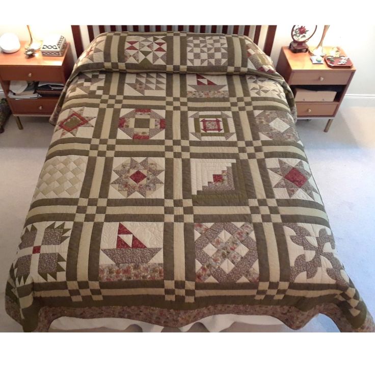 a bed with a brown and white quilt on it's headboard next to a night stand