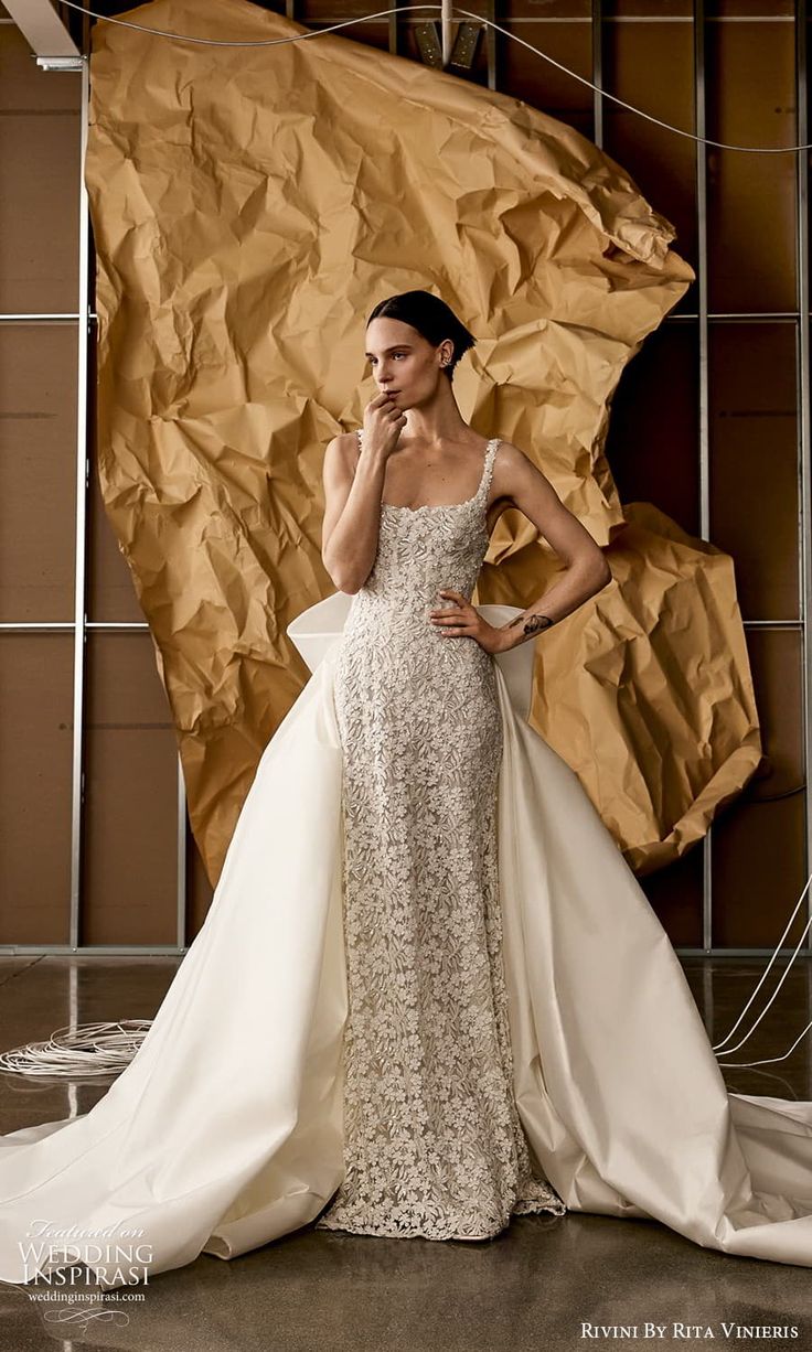 a woman in a wedding dress is posing for a photo with her hand on her face