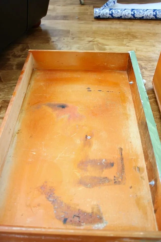 an empty wooden tray sitting on top of a hard wood floor