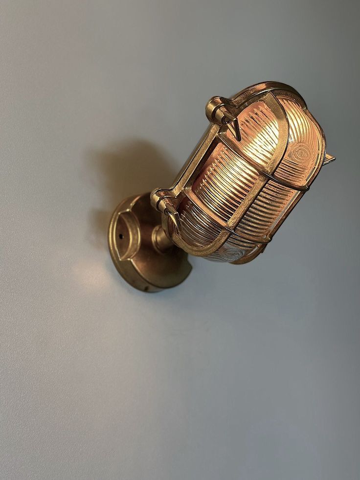 an old fashioned brass wall light on a white wall