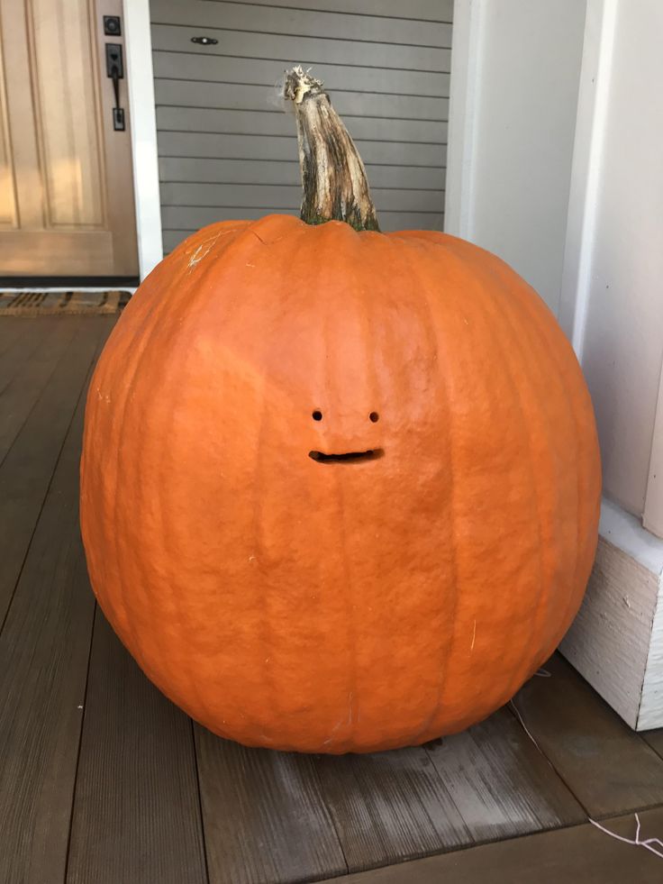 a large pumpkin sitting on top of a wooden porch