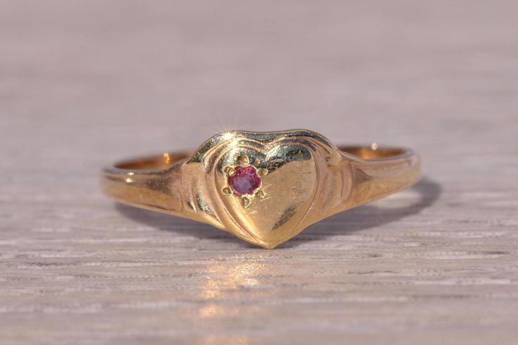 This stunning piece, known as The Heartfelt Ruby, features a captivating natural ruby set at the center of a heart motif. The natural ruby adds a touch of color and elegance, making it a delightful piece for any collection. The ring is crafted in yellow gold and is currently a finger size 4 but can be adjusted to any finger size for an additional charge upon request, ensuring a perfect fit. Love this piece, but don't have the money to spend right now? We offer FREE layaway on every item in our shop. With just 20% down, take one full year (interest-free) to pay off your new jewelry! There are no hidden fees or charges, ever. For more information on our layaway policy, please contact us. Each piece has been hand-selected and meticulously identified and graded by a Graduate Gemologist who has Classic Heart Shaped Birthstone Jewelry, Classic Heart-shaped Birthstone Jewelry, Classic Heart-shaped Gemstone Jewelry, Classic Heart-shaped Ruby Ring For Formal Occasions, Classic Heart-shaped Red Ruby Ring, Classic Red Heart-shaped Ruby Ring, Elegant Red Heart Ring In 14k Gold, Heart-shaped Ruby Jewelry For Wedding, Heart-shaped Ruby Ring For Valentine's Day