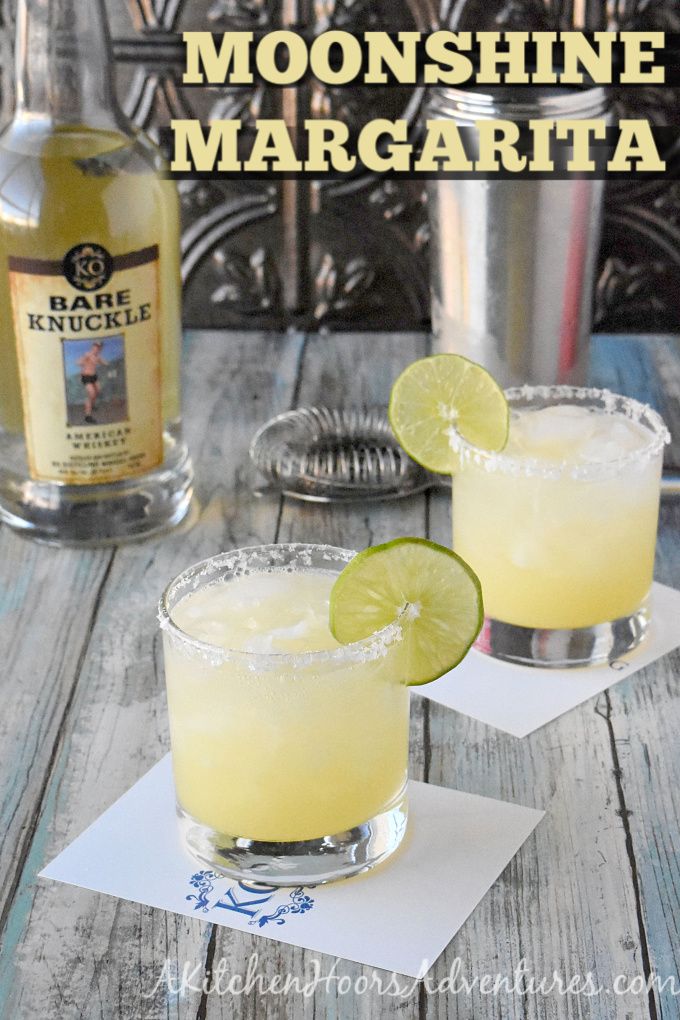 two glasses filled with lemonade margarita on top of a wooden table