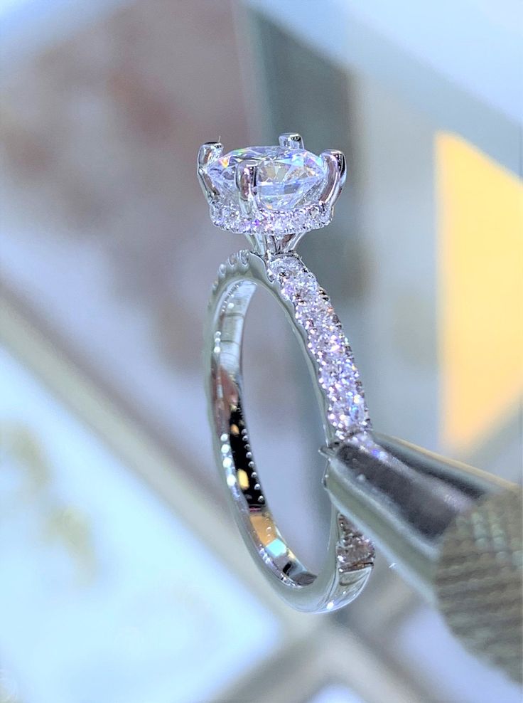 a diamond ring is being held by a pair of scissors