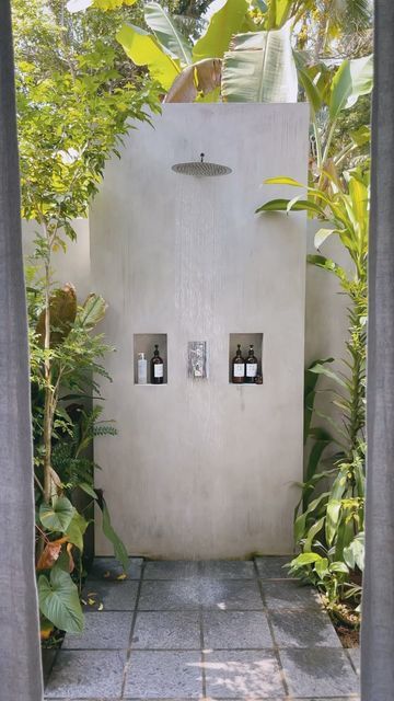 an outdoor shower in the middle of a garden