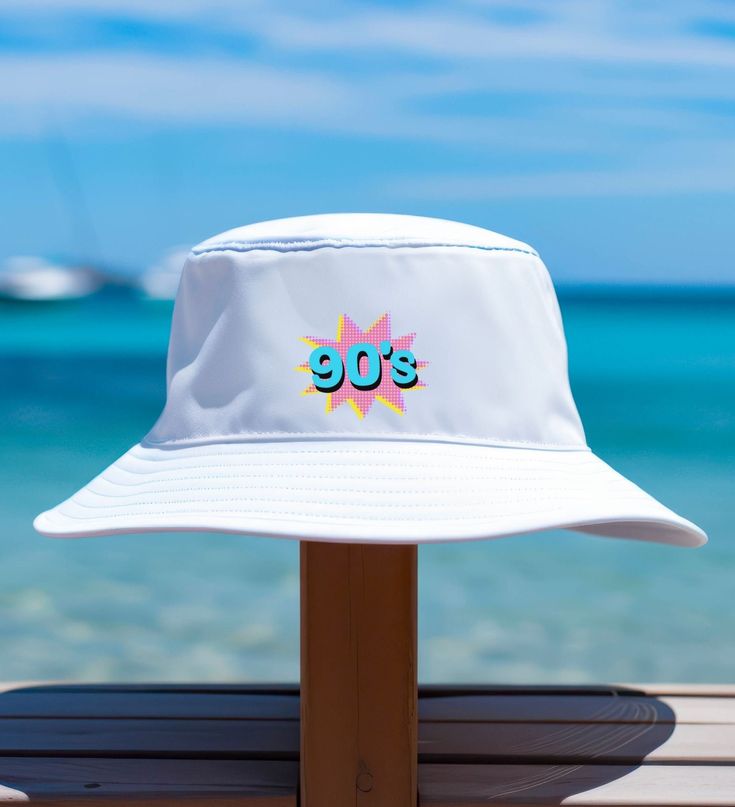 a white hat with the word 90's on it sitting on top of a wooden table