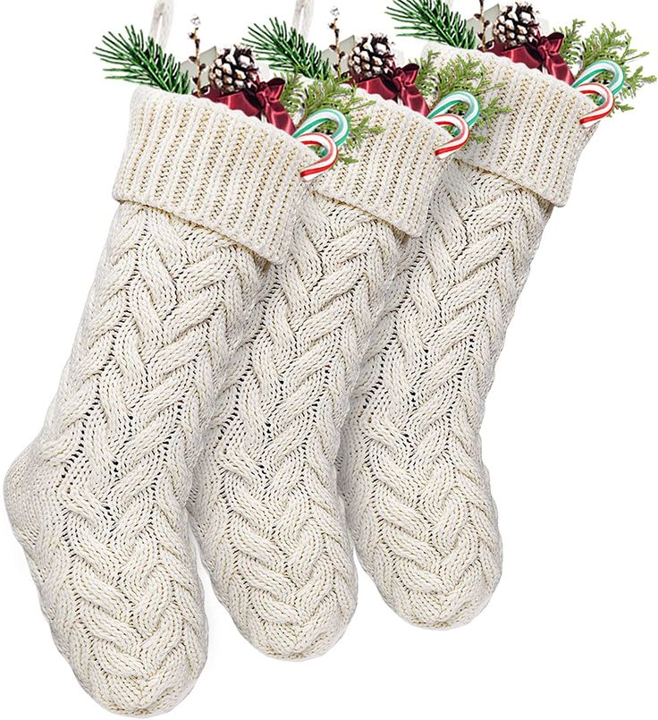 three christmas stockings with candy canes and pine cones hanging from the top of them