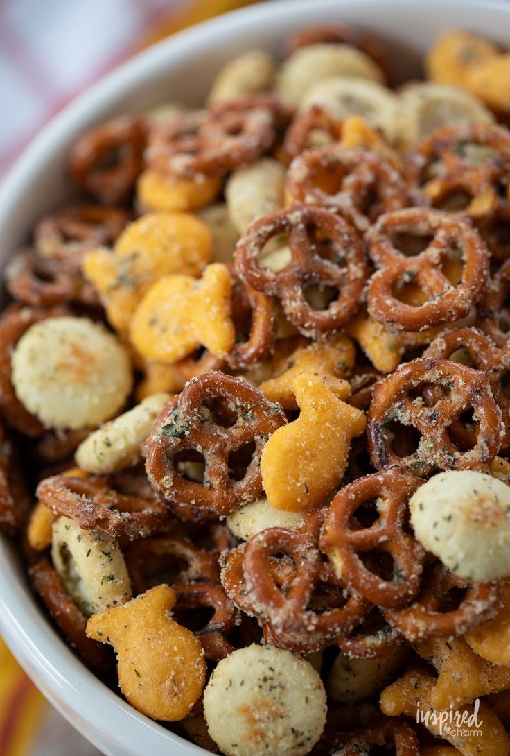 a bowl filled with cheetos and pretzels on top of a table