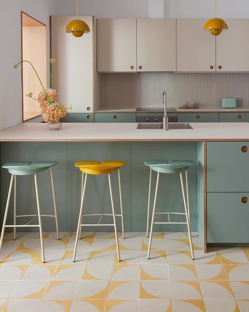 three stools in front of a kitchen island with yellow and white tiles on the floor