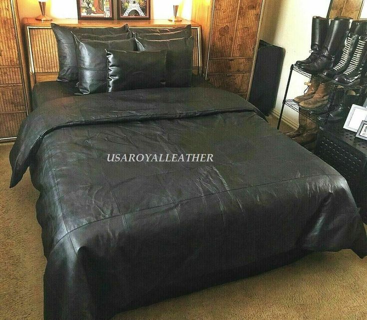 a bed with black leather sheets and pillows