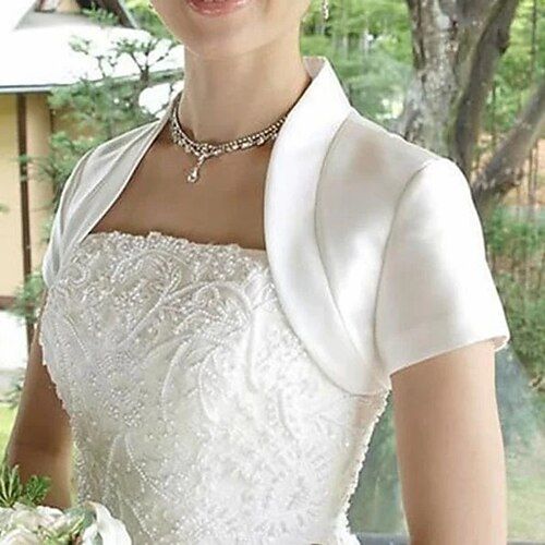 a woman in a white dress holding a bouquet and wearing a tiara with flowers on it