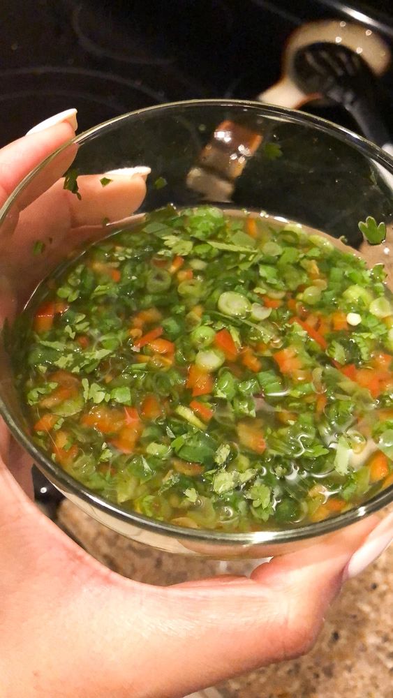 a person holding a glass bowl filled with vegetables