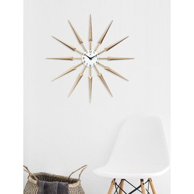 a white chair sitting in front of a clock on the wall next to a basket