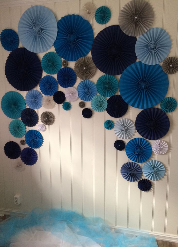 blue and silver paper fans hanging on the wall