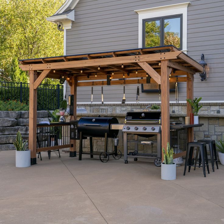 an outdoor kitchen with grill and seating area