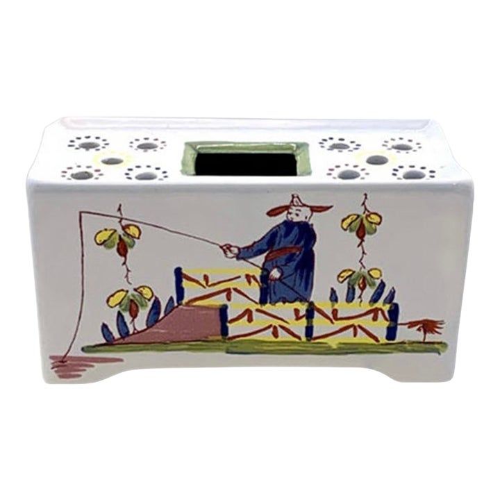 a ceramic tissue box with an image of a man fishing