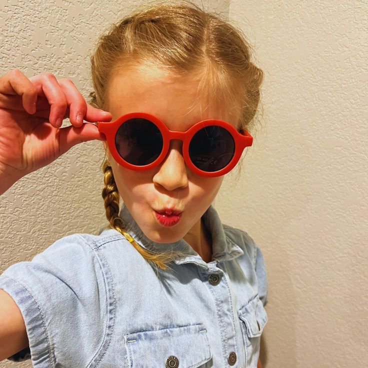 Introducing our Modern Circular Kids Sunglasses, the perfect fusion of contemporary style and playful charm. These sunglasses feature a sleek circular frame that adds a trendy touch to any outfit. Designed with children in mind, they offer a lightweight and comfortable fit for all-day wear. The UV lenses provide essential sun protection, ensuring your little one's eyes are shielded from harmful rays. Red Plastic Sunglasses For Summer, Playful Red Sunglasses With Uv Protection, Cute Red Sunglasses With Uv Protection, Cute Red Sunglasses For Summer, Fun Red Sunglasses With Gradient Lenses, Fun Red Plastic Sunglasses, Fun Red Sunglasses, Casual Plastic Round Frame Sunglasses, Fun Red Sunglasses For The Beach