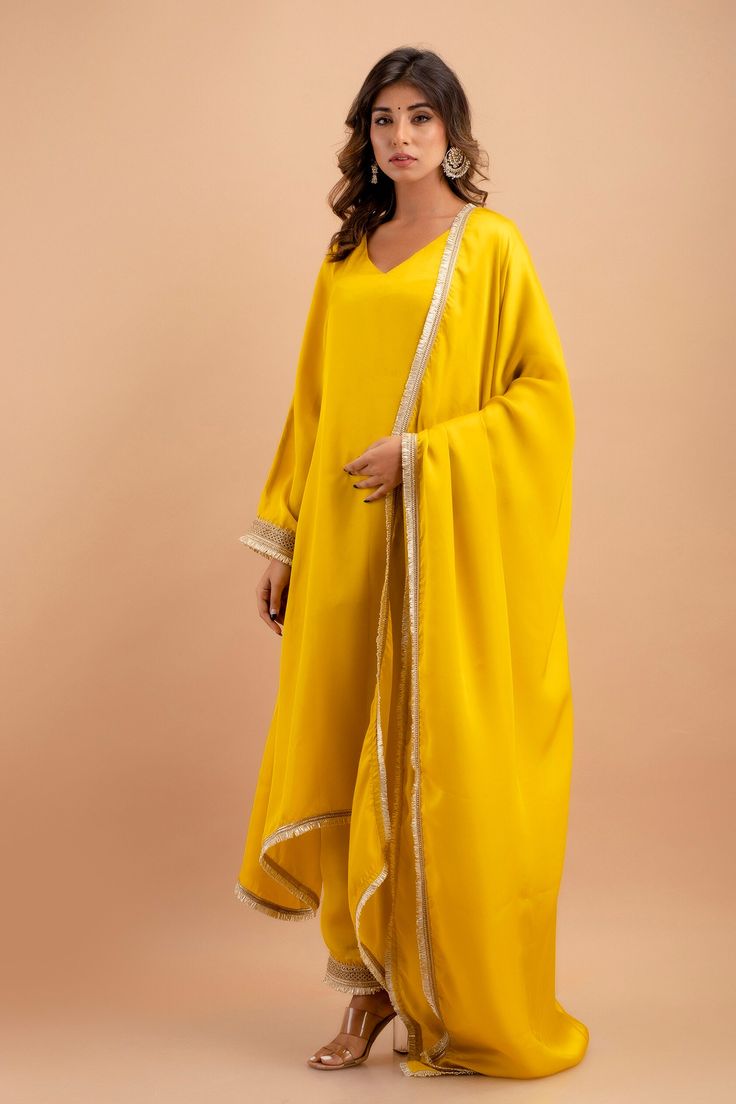 Step into the world of timeless elegance with our handcrafted Silk Kurta Set, a perfect blend of traditional grace and contemporary style. This exquisite ensemble includes a stunning kurta, a pair of breezy palazzos, and a flowing dupatta, each piece accentuated with delicate Gota lace attachments that add a touch of golden shimmer to your every move. The kurta, measuring an impressive 48 inches in length, gracefully drapes over your form, while the palazzos offer a comfortable 39-inch length fo Yellow Anarkali Palazzo Set With Embroidered Border, Yellow Embroidered Palazzo Set For Festivals, Elegant Yellow Palazzo Set With Traditional Drape, Elegant Yellow Palazzo Set For Eid, Yellow Palazzo Set With Embroidered Border For Diwali, Diwali Yellow Palazzo Set With Embroidered Border, Diwali Yellow Embroidered Palazzo Set, Elegant Yellow Palazzo Set With Dabka Work, Elegant Yellow Salwar Kameez With Gota Work