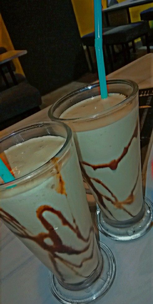 two glasses filled with ice cream sitting on top of a table next to each other