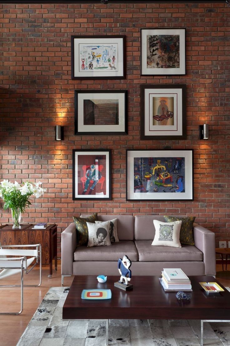 a living room filled with furniture and framed pictures on the wall above it's coffee table