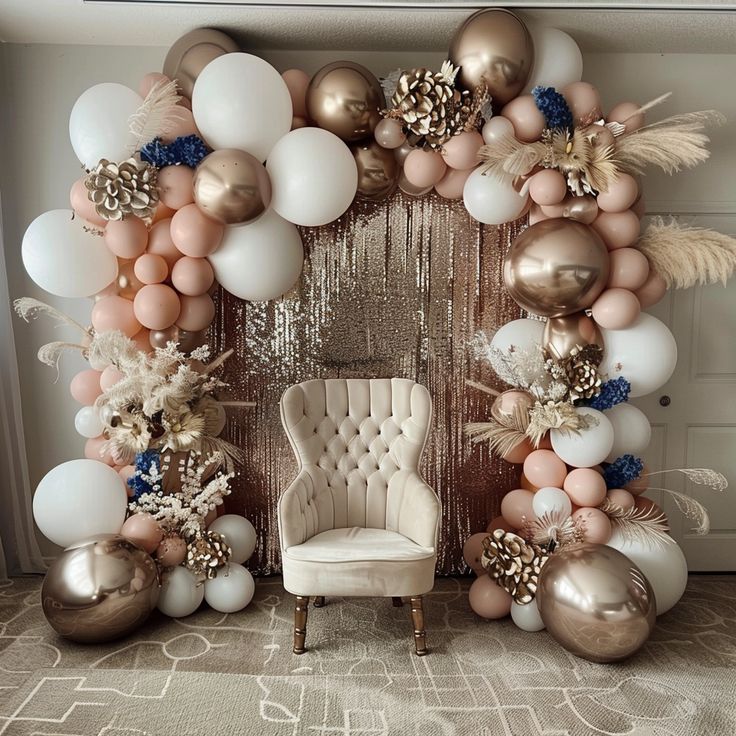 a chair sitting in front of a large balloon arch with balloons and feathers on it