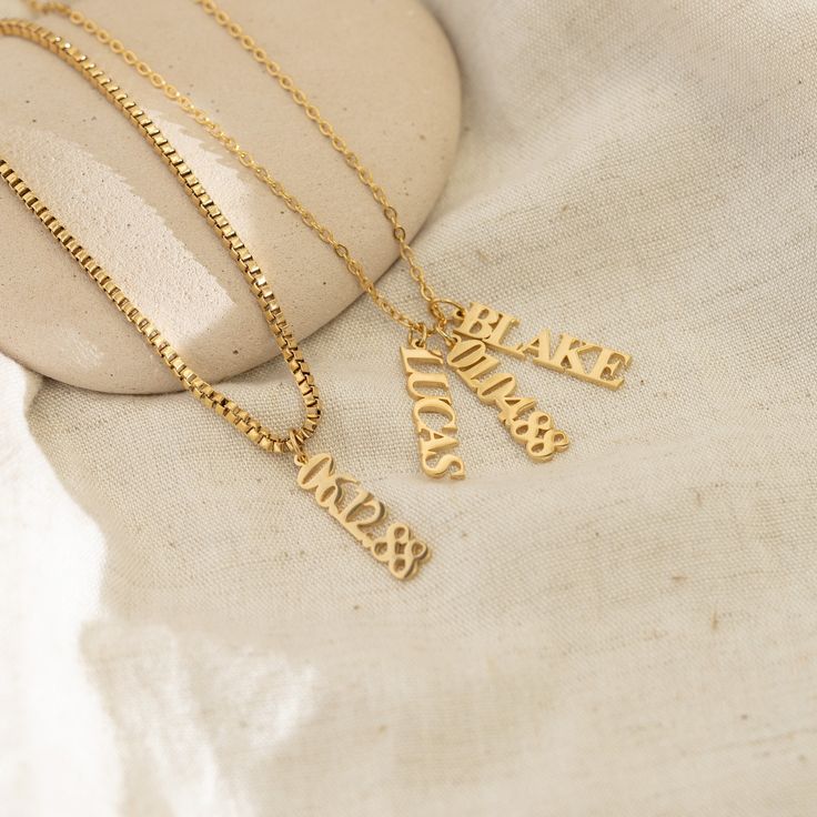 Uplift your jewelry collection with our elegant Vertical Personalized Name Necklace. Perfect for the fashion-savvy, its customized engraving and 18k Gold composition fuse timeless charm with lasting quality. Materials & Finish: * High-Quality Stainless Steel * 18k Gold, Silver Our Products are different from regular gold plating because it is a THICK layer of 18k solid gold on stainless steel, making it more durable. It offers the appearance and quality of gold jewelry at a more affordable cost. Classic Engraved Snake Chain Jewelry, Elegant Yellow Gold Name Necklace With Box Chain, Box Chain Necklace For Mother's Day Anniversary, Mother's Day Anniversary Box Chain Necklace, Classic Initial Pendant Box Chain Jewelry, Classic Initial Pendant Jewelry With Box Chain, Elegant Nameplate Box Chain Jewelry, Anniversary Nameplate Charm Necklace, Classic Box Chain Jewelry With Initial Pendant