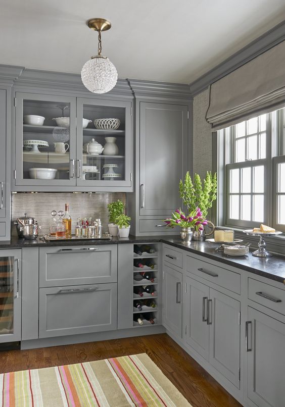 a kitchen with gray cabinets and striped rug