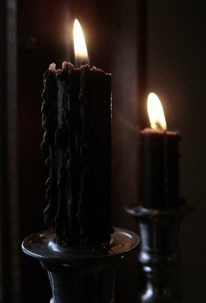 two lit candles sitting next to each other on a table