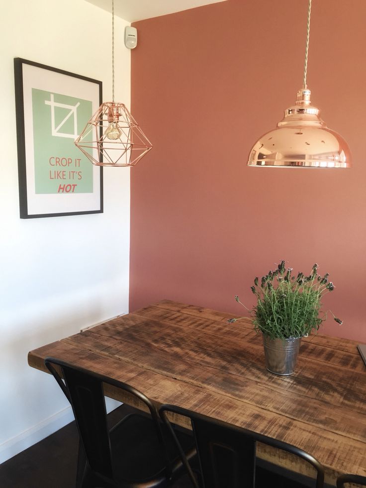 a wooden table with two chairs and a potted plant sitting on top of it